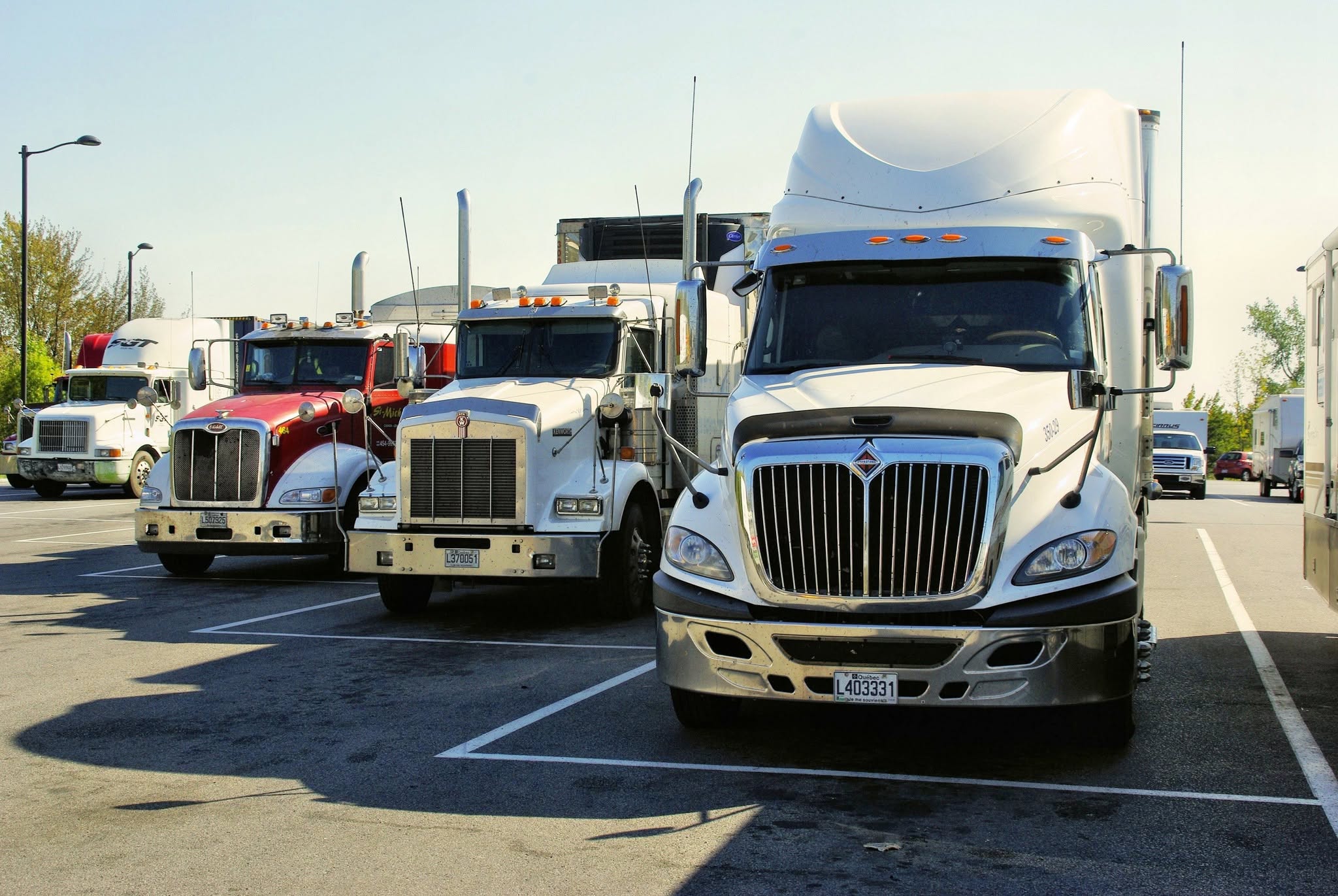 A lineup of professional tractor-trailers parked at a truck stop
